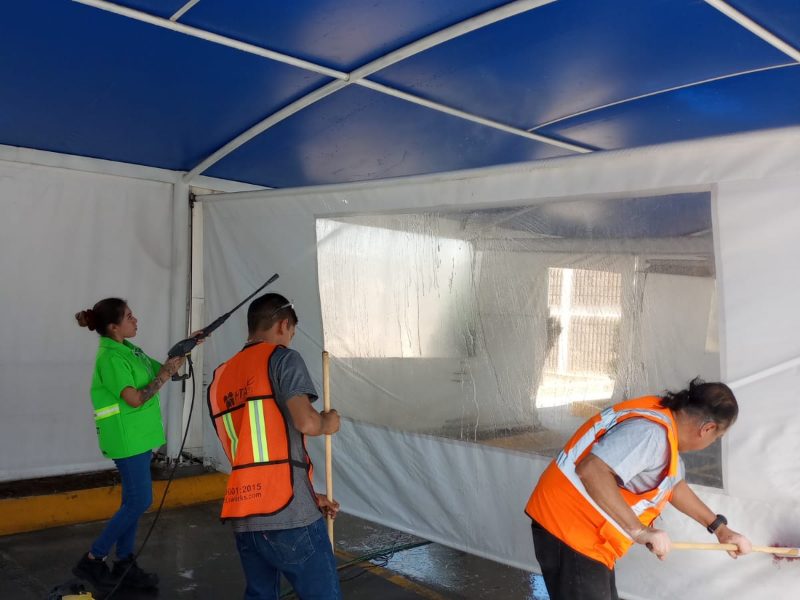 Cuadrilla de HTA Cleans lavando los toldos del estacionamiento de una planta