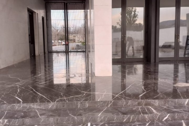 Interior terminado con cancelería y piso de mármol tras la limpieza de obra