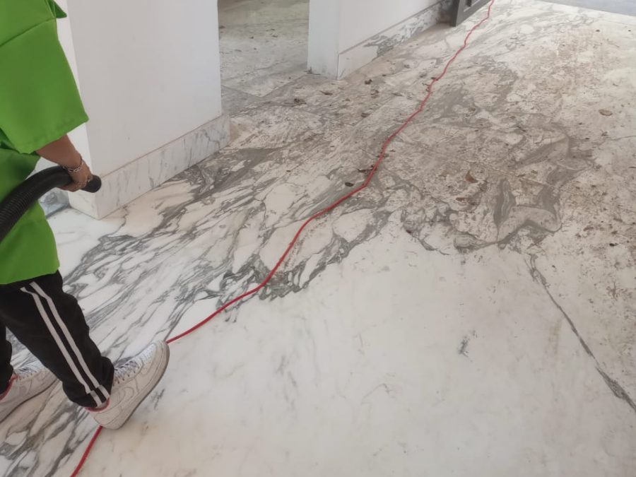 Piso de mármol con polvo y residuo de obra durante la limpieza